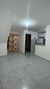 an empty room with a kitchen and a tiled floor at Apto próx a PRAIA in Paulista