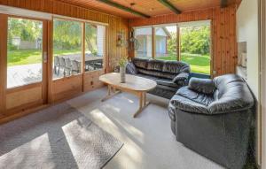 a living room with leather couches and a table at Stunning Home In Tarm With Sauna in Højsand