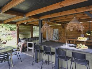 an outdoor kitchen with a bar and chairs at Casa Familia in Sint Annaland