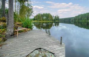 a wooden dock with a bench next to a lake at 2 Bedroom Awesome Home In Töcksfors in Navarsviken