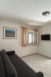 a living room with a couch and a television at Apartments by the sea Lumbarda, Korcula - 4446 in Lumbarda