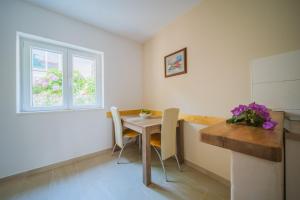 a kitchen with a table and chairs and a window at Apartments by the sea Lumbarda, Korcula - 4446 in Lumbarda