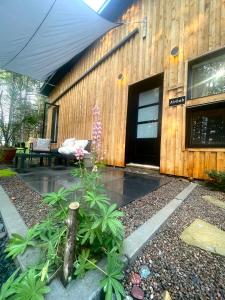 a wooden building with a patio with a table and flowers at Le 1040 St-Mathieu du Parc in Saint Mathieu Du Parc