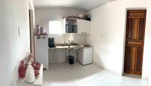 a small white kitchen with a sink and a refrigerator at COP 30 Apartamento próximo do Hangar in Belém