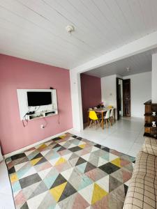 un salon avec une télévision et un sol coloré dans l'établissement COP 30 Apartamento próximo do Hangar, à Belém