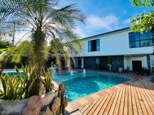 a swimming pool in front of a house at Finca La Casa de Pablo in Doradal