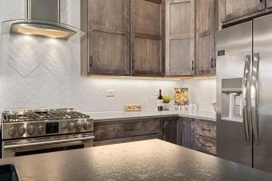 a kitchen with stainless steel appliances and wooden cabinets at Scenic Mountain Retreat Golf, Pickleball, Relax in Loveland