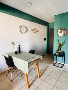 a dining room table with chairs and a clock on the wall at Altos de Barrio Sur in San Miguel de Tucumán +6 photos