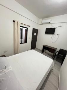 サンタ・クルス・デ・ラ・シエラにあるHabitación cercana al centro de la ciudadの大きな白いベッドとテレビのある寝室