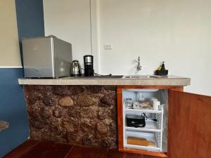 a small kitchen with a counter with a small refrigerator at Suite Tierra, Reconnect with your roots in Puerto Baquerizo Moreno