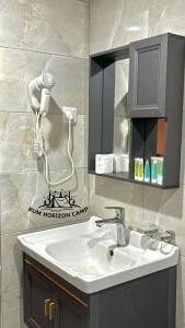a bathroom with a sink and a hair dryer at Rum Horizon luxury camp in Wadi Rum