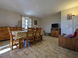a living room with a table and chairs and a television at Gîte restauré avec grand terrain clos, salle de jeux, proche du Puy en Velay et Chavaniac-Lafayette - FR-1-582-297 in Jax