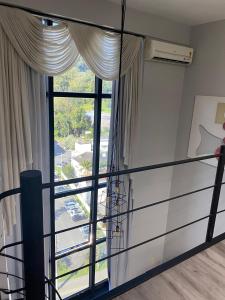 a room with a balcony with a large window at Saint Sebastian Flat 613 - Com Hidro! Até 3 pessoas, Duplex, no Centro in Jaraguá do Sul +11 photos