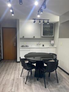 a room with a table and chairs and a kitchen at Saint Sebastian Flat 613 - Com Hidro! Até 3 pessoas, Duplex, no Centro in Jaraguá do Sul