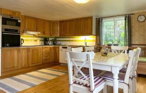Torpにある2 Bedroom Awesome Home In Arbogaのキッチン(木製キャビネット、白いテーブルと椅子付)
