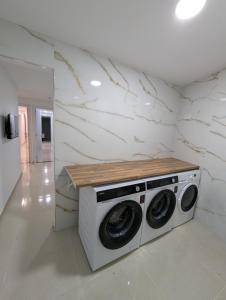 eine Waschmaschine und einen Trockner in einem Zimmer mit einer Theke in der Unterkunft Apartamento Anau F - Playa - Yumbo in San Bartolomé de Tirajana + 86 Fotos