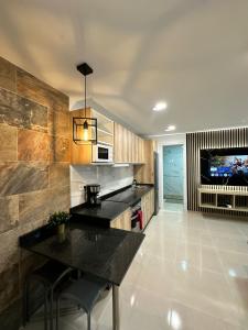 eine Küche mit einer schwarzen Arbeitsplatte und einem TV in der Unterkunft Apartamento Anau F - Playa - Yumbo in San Bartolomé de Tirajana