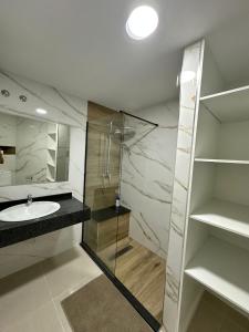 ein Badezimmer mit Waschbecken und Glasdusche in der Unterkunft Apartamento Anau F - Playa - Yumbo in San Bartolomé de Tirajana