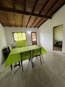 ein Esszimmer mit einem grünen Tisch und Stühlen in der Unterkunft Cabañas del Sur in Mar del Plata