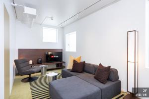 a living room with a couch and a chair at JAPAVISTA r4 in Tokyo