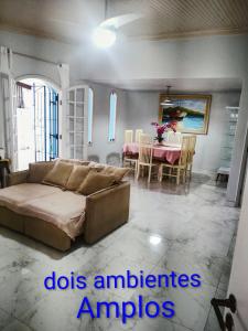 a living room with a bed and a dining room at Casa Dna Nair Gus in Ubatuba