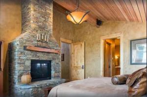 a bedroom with a stone fireplace and a bed at Luxury Home with Stunning 4 Peak Views in Tetonia