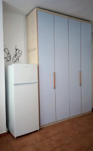 a room with white cabinets and a refrigerator at Hestia Plus in Nafplio