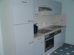 a white kitchen with a sink and a stove at Holiday apartment in Ramsberg