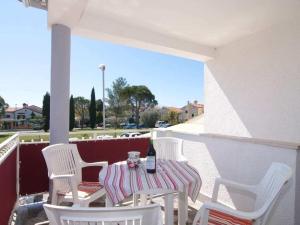a table and chairs on a balcony with a bottle of wine at Holiday apartment in Porec with swimming pool in Poreč