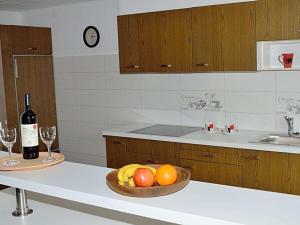 a kitchen with a bowl of fruit and a bottle of wine at Cabin in Ofterschwang with swimming pool in Sigiswang +13 photos