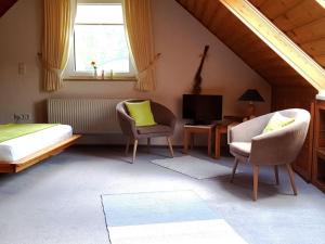 a bedroom with a bed and two chairs and a television at Holiday home with 2 bedrooms in Burggaillenreuth