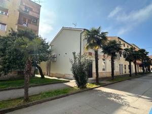una strada con palme di fronte a un edificio di Apartment Urban Green a Poreč (Parenzo)