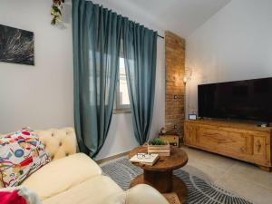 un soggiorno con divano e TV a schermo piatto di Apartment Urban Green a Poreč (Parenzo)