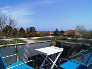ホーヴァハトにあるApartment in Hohwacht with swimming poolの白いテーブルと椅子付きのバルコニー