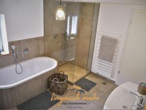 a bathroom with a tub and a toilet and a sink at Bavarian holiday apartment more in Gstadt am Chiemsee +7 photos