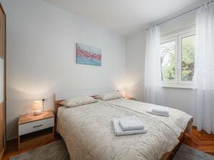 a white bedroom with a bed with two towels on it at Apartment Maria in Poreč