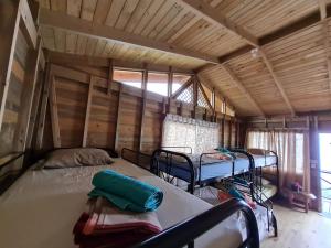 a bedroom with two beds in a room with wooden walls at Cabañas Bonnysu in Buenos Aires