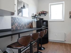 a kitchen with a counter with chairs and a refrigerator at Holiday apartment with 4 bedrooms in Eisenach