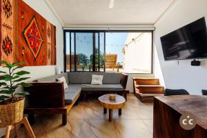 a living room with a couch and a tv at Unmatched Suite, two bedrooms facing Zicatela in Brisas de Zicatela
