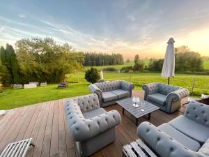 patio con divani, tavolo e ombrellone di Tiny House Alpenpanorama Chalet Igluhut a Mollenberg