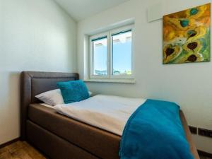 ein kleines Schlafzimmer mit einem Bett mit Fenster in der Unterkunft Holiday apartment with 2 bedrooms in Kalzhofen