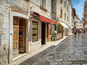 a cobblestone street with people walking down the street at Deluxe Apartment Antonija in Poreč