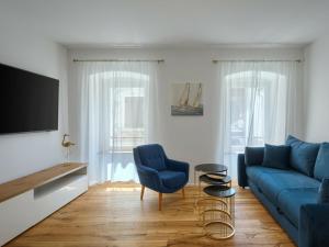 a living room with a blue couch and a tv at Deluxe Apartment Antonija in Poreč