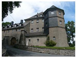 a large brick building with a clock tower at Long 4 stars with balcony in Schauenstein