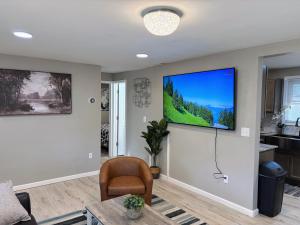 Una sala de estar con un televisor de pantalla plana en una pared. en Your Cozy Home Away From Home king bed, parking, en West Seneca