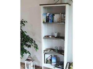 a white book shelf with books on it at in Fischers Hus in Stenderup