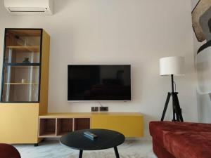 ein Wohnzimmer mit einem Flachbildfernseher an der Wand in der Unterkunft Oliva Verde Residence in Santalezi