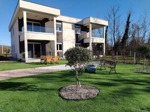ein Gebäude mit einem Baum davor in der Unterkunft Oliva Verde Residence in Santalezi