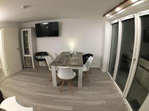ブラウンラーゲにあるHoliday apartment with 3 bedroomsのテーブルと白い椅子のあるダイニングルーム