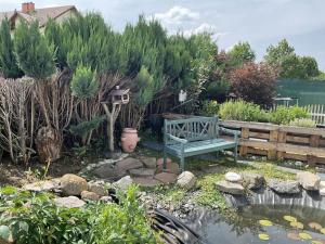 a green bench in a garden with a pond at Holiday home in Erbach with swimming pool in Dorf Erbach